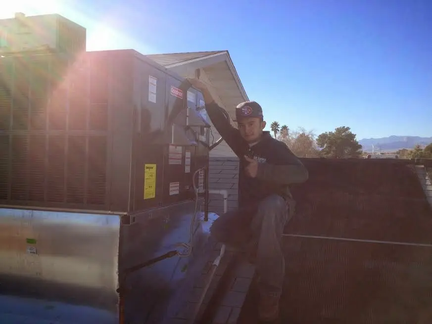 HVAC technician performing Heat Pump Repair on a rooftop unit in Standish